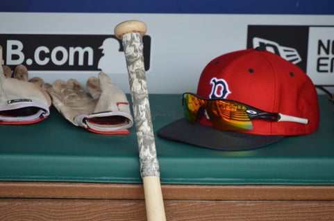 A player's hat, gloves, and bat lay on the bench before the Red Sox-Rangers game on June 25, 2016. (Source: I Am Second)