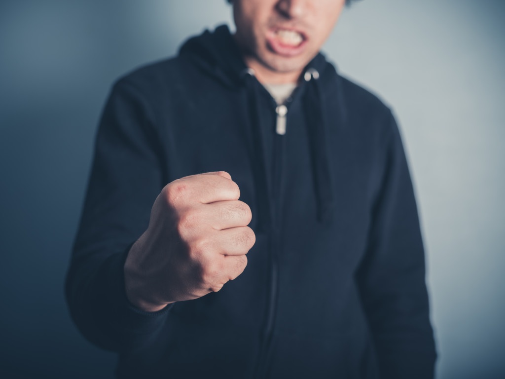 Close up on a young man raising his fist